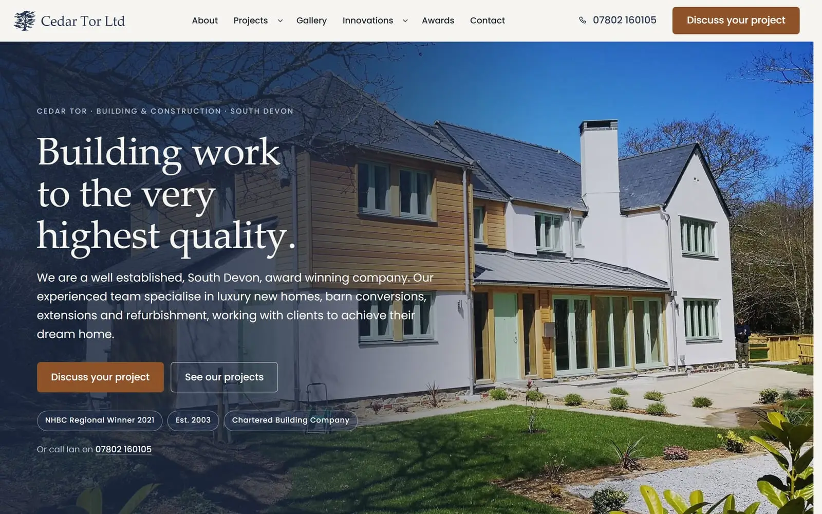 A building and construction website shown in a browser window with the matching phone view: an award-winning new build in timber and render under a blue sky