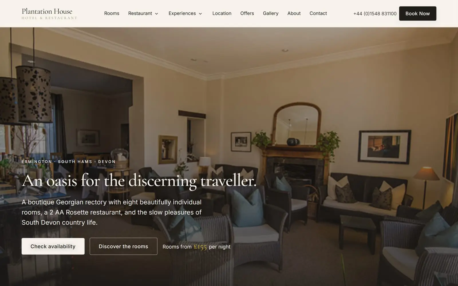 A boutique hotel and restaurant website shown in a browser window with the matching phone view: the lounge with deep sofas and a lit fireplace behind the headline "An oasis for the discerning traveller"